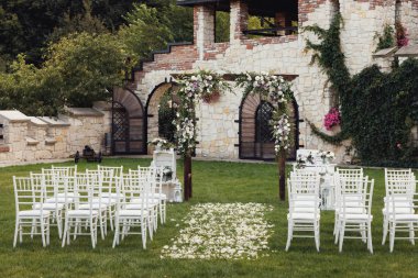 düğün kemer ve sandalyeler parkta yeşil çimenlerin üzerinde. Düğün töreni süslemeleri