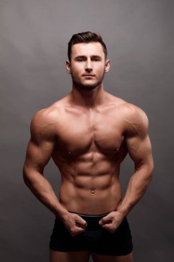 Seksi güçlü vücut geliştiricisi. Vücut geliştirmeci adamla mükemmel abs, omuzlar, pazı, triceps, göğüs.