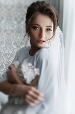 Gelin Düğün sabahı. Beyaz lüks elbise içinde muhteşem gelin düğün için hazırlanıyor. Sabah hazırlıkları.