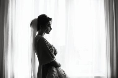 Gelin Düğün sabahı. Beyaz lüks elbise içinde muhteşem gelin düğün için hazırlanıyor. Sabah hazırlıkları.