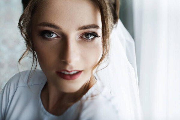 Свадебное утро невесты. Великолепная невеста в белом роскошном платье готовится к свадьбе. Утренние приготовления
.