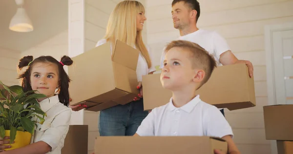 Ευτυχισμένη Οικογένεια Δύο Παιδιά Στο Νέο Σπίτι Οικογένεια Χαρτόνι Κουτιά — Φωτογραφία Αρχείου
