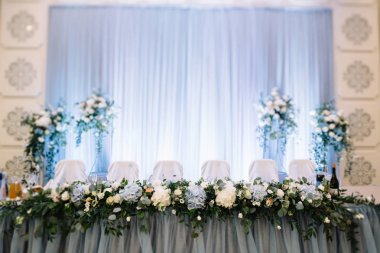 Gelin ve damat için bez ve bez ile süslenmiş şölen masası.