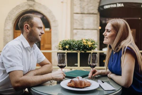 Young couple with glasses of red wine in a restaurant .