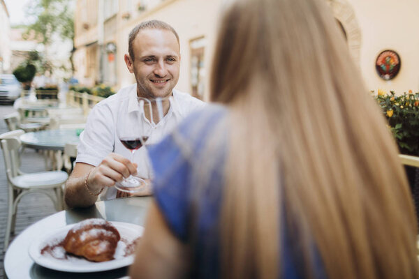 Young couple with glasses of red wine in a restaurant . 