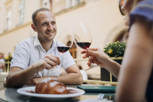 Pareja joven con copas de vino tinto en un restaurante  . — Foto de Stock