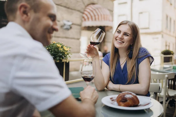 Pareja joven con copas de vino tinto en un restaurante  . — Foto de Stock