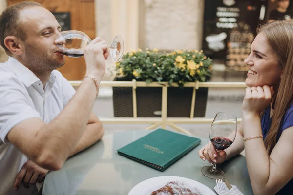 Pareja alegre en un restaurante con copas de vino tinto. Joven — Foto de Stock