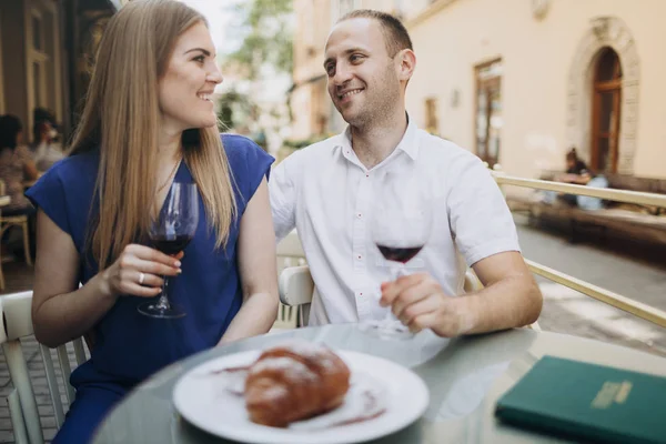 Young couple with glasses of red wine in a restaurant .