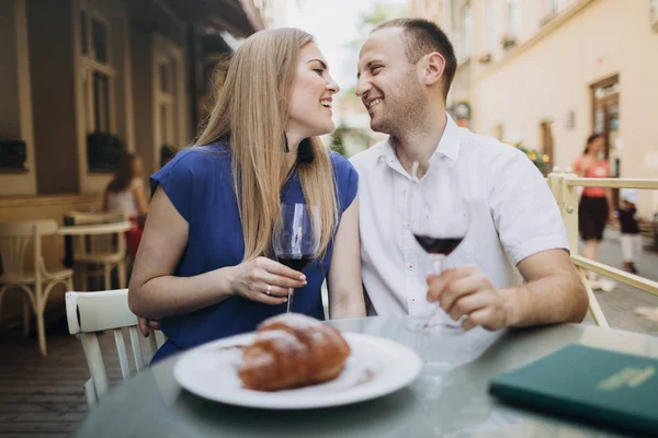 Pareja alegre en un restaurante con copas de vino tinto. Joven — Foto de Stock