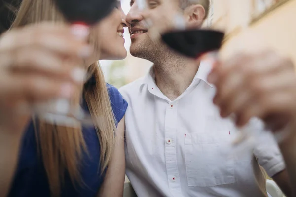 Young couple with glasses of red wine in a restaurant .