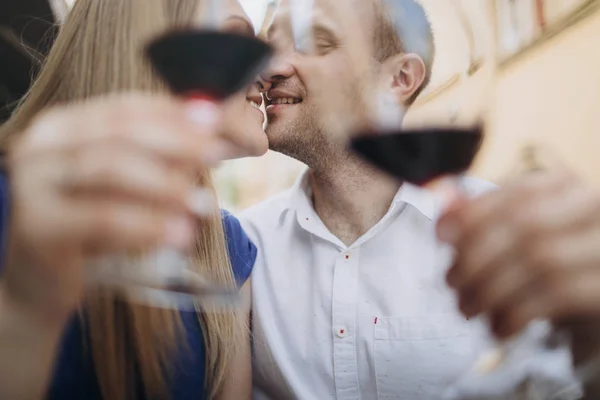 Pareja alegre en un restaurante con copas de vino tinto. Joven — Foto de Stock