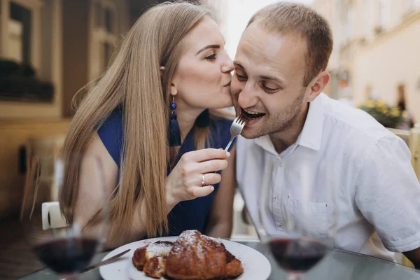 Young couple with glasses of red wine in a restaurant .