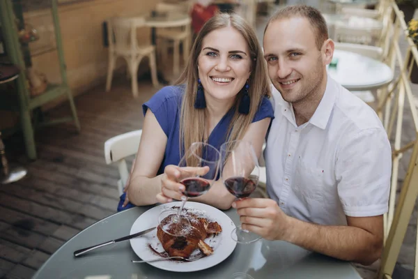 Pareja joven con copas de vino tinto en un restaurante  . — Foto de Stock