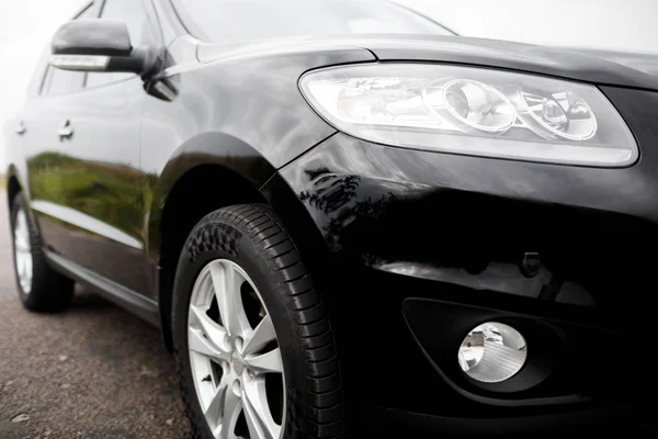 Black modern car closeup. Black modern car headlights - front vi — Stock Photo, Image
