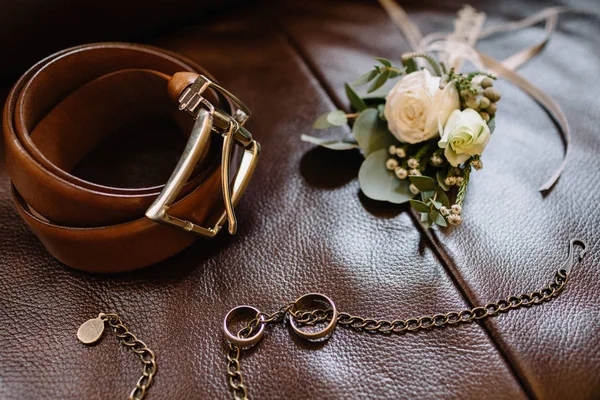 Wedding accessories. Groom accessories. Wedding details. Closeup of elegant stylish brown male shoes. Preparation for wedding concept. Horizontal photo. Wedding rings made of gold. Close-up.