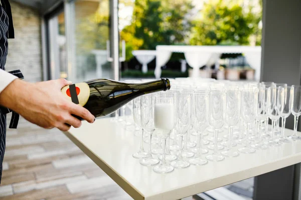 Elegant glasses with champagne standing in a row on serving tabl — Stock Photo, Image