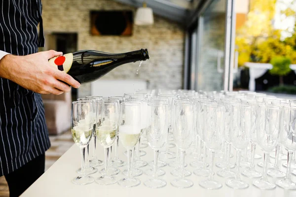 Elegant glasses with champagne standing in a row on serving tabl — Stock Photo, Image