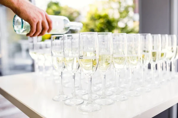 Copos elegantes com champanhe de pé em uma fileira em servir mesa — Fotografia de Stock