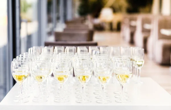 Full cold champagne flutes stand between buckets on dinner table — Stock Photo, Image