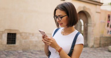 Şehirde, akıllı telefon kullanan mutlu güzel kız yaz kız 