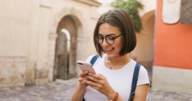Şehirde, akıllı telefon kullanan mutlu güzel kız yaz kız 