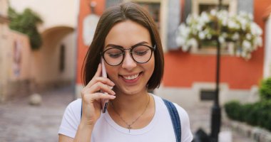 Şehirde, akıllı telefon kullanan mutlu güzel kız yaz kız 