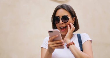 Şehirde, akıllı telefon kullanan mutlu güzel kız yaz kız 