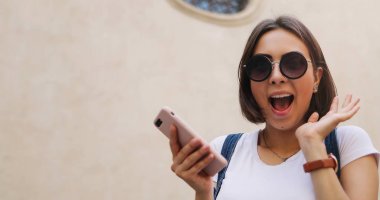 Şehirde, akıllı telefon kullanan mutlu güzel kız yaz kız 