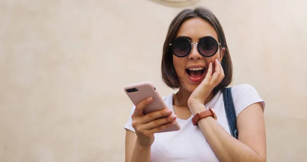 Feliz hermosa chica usando el teléfono inteligente en la ciudad, chica de verano — Foto de Stock