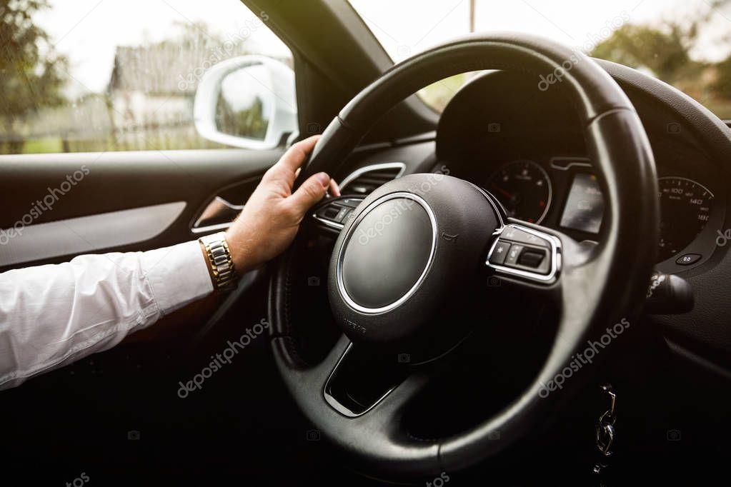  Close-up of a mans hand holding a  car helm. Man driving his c