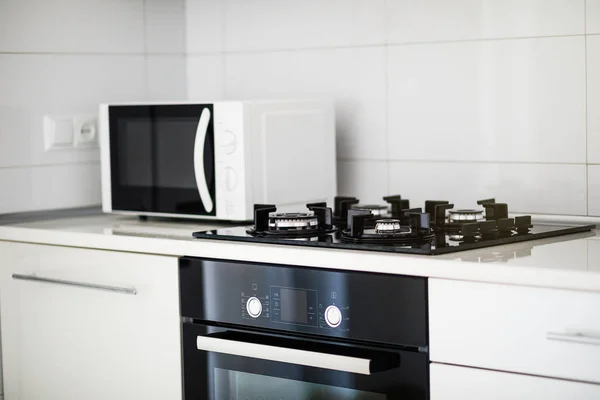 Interior de cozinha moderna com forno elétrico e microondas . — Fotografia de Stock