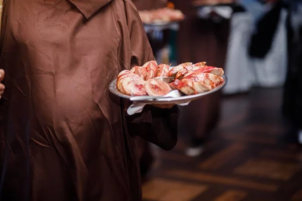 medivian Waiter carrying plates with meat dish at a wedding