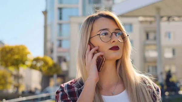 Retrato al aire libre de una joven rubia hablando con su smartphone —  Fotos de Stock