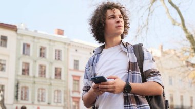 şehirde bir akıllı telefon kullanan genç adam