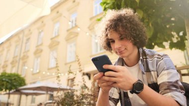 şehirde bir akıllı telefon kullanan genç adam