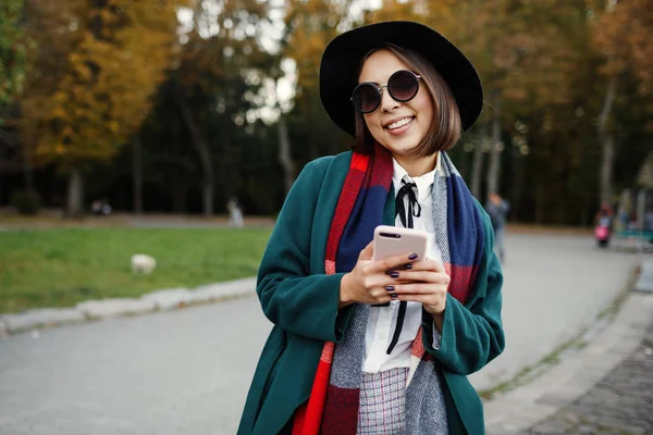 Retrato al aire libre alegre y elegante chica hipster en sombrero usando — Foto de Stock
