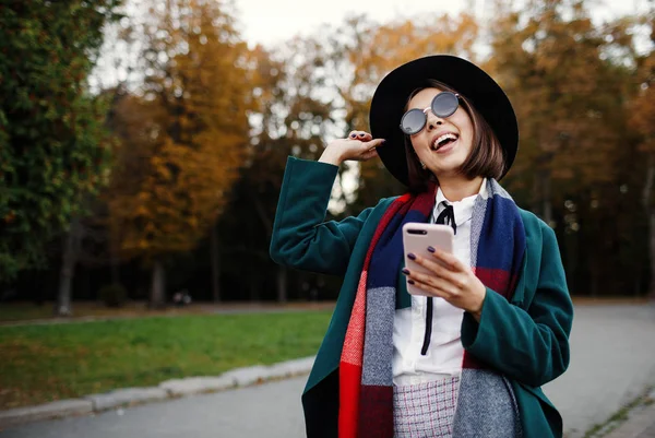 Retrato al aire libre alegre y elegante chica hipster en sombrero usando —  Fotos de Stock