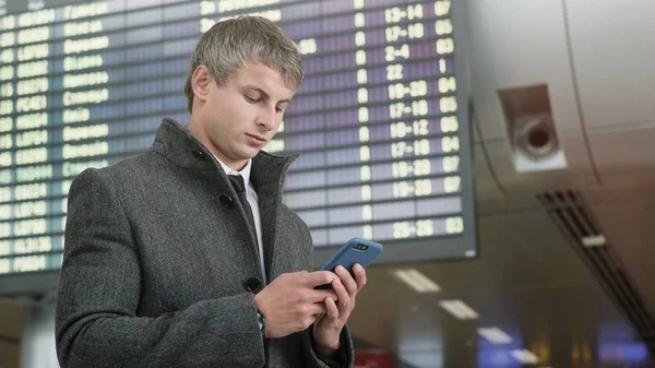 Handsome businessman in a city. Portrait of handsome business man using smartphone  in the city.