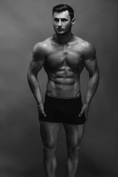 黑色和白色近距离写照的健身运动小男孩显示肌肉 坚强的人在背景上摆姿势 — 图库照片