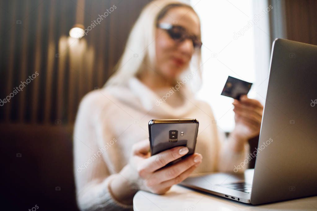 Woman with phone. Online payment. Women hands using smartphone and laptop computer for online shopping. Payment Detail page display.