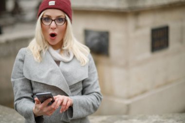 Şehrin modern bir akıllı telefon kullanan güzel kadın.