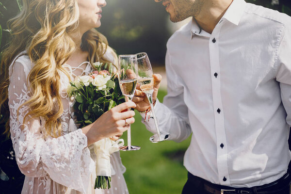 Couple with champagne glasses.   Beautiful young couple drinking champagne on the wedding ceremony.