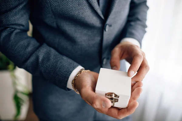 La mano del hombre sosteniendo anillos de compromiso — Foto de Stock