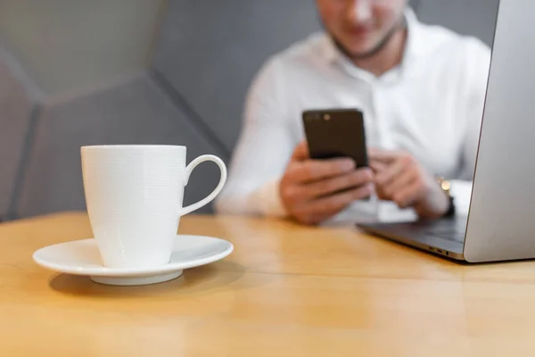 Portret Młodzieńca Telefonem Komórkowym Siedząc Kawiarni Przy Użyciu Laptopa — Zdjęcie stockowe