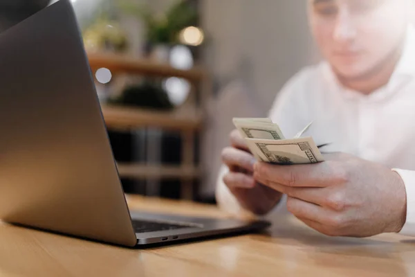 man with laptop and money on background.