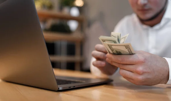 man with laptop and money on background.