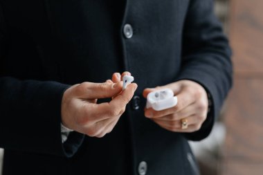 Kablosuz kulaklık sokaklarda gösterilen genç adam. Airpods olan adam.