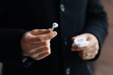 Kablosuz kulaklık sokaklarda gösterilen genç adam. Airpods olan adam.
