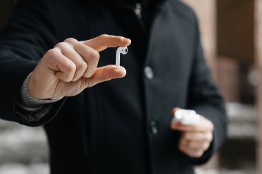 Kablosuz kulaklık sokaklarda gösterilen genç adam. Airpods olan adam.
